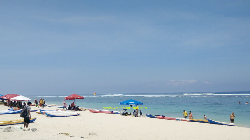 Pengunjung menikmati suasana tenang Pantai Pandawa dengan payung dan ombak yang tenang di Bali