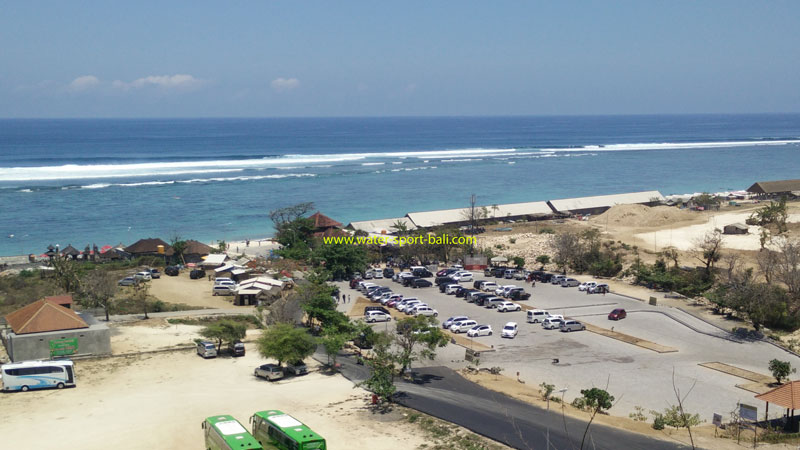 Area parkir yang luas di Secret Beach dengan latar pantai dan laut biru terang