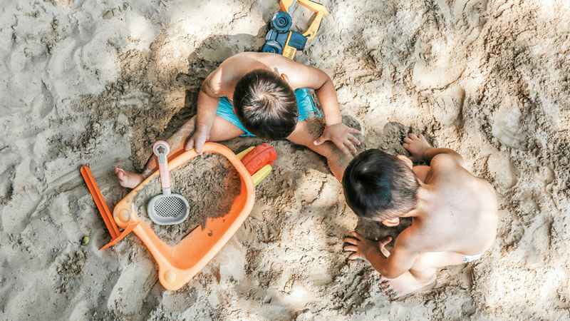 Anak-anak bermain pasir di pantai. Tips Liburan Ke Bali Dengan Balita