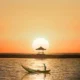 Sunrise di Pantai Sanur dengan perahu nelayan dan gazebo Bali