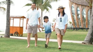 Keluarga bahagia berjalan di taman resort tepi pantai Legian, Bali