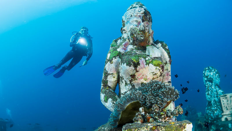 Keindahan bawah laut Nusa Penida dengan Buda Statue dan terumbu karang berwarna-warni.