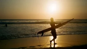 Peselancar di Pantai Batu Bolong saat matahari terbenam