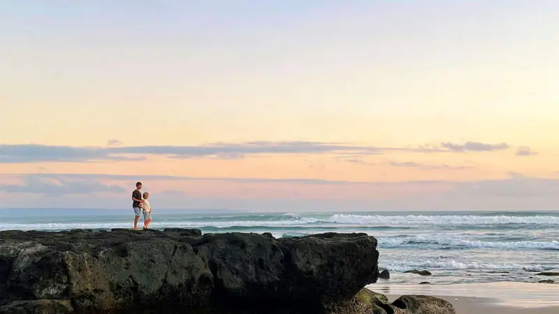 Pasangan menikmati matahari terbenam di Pantai Batu Bolong