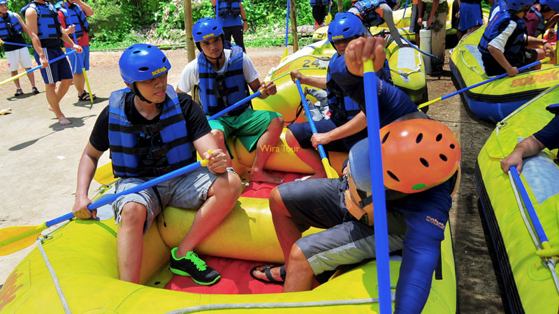 Keluarga belajar mengayuh sebelum arung jeram di Bali