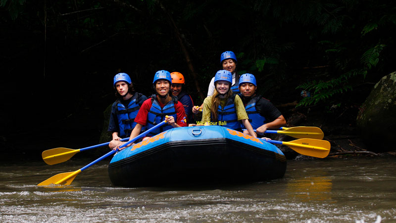 Foto orang-orang sedang beraksi di rakit saat arung jeram