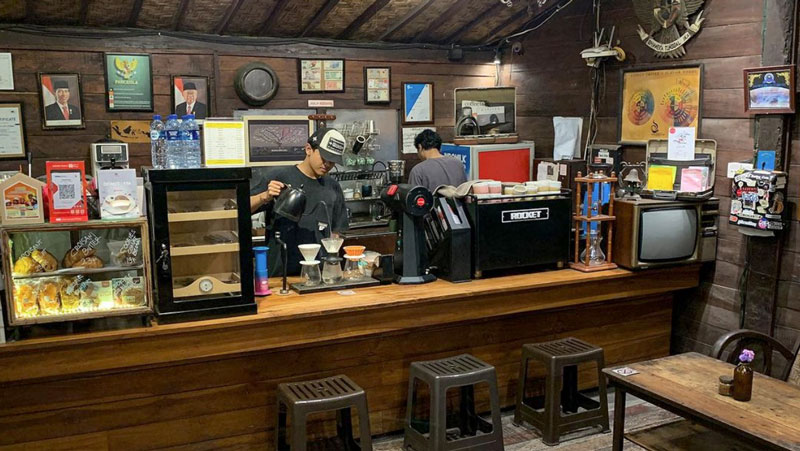 Dua barista menyiapkan kopi di kafe bergaya vintage di Denpasar.