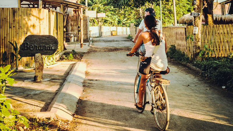 Wisatawan bersepeda di jalan desa Gili Trawangan