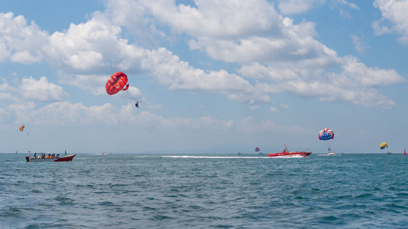 Pengunjung Parasailing dengan Berbagai Warna Parasut di Bali