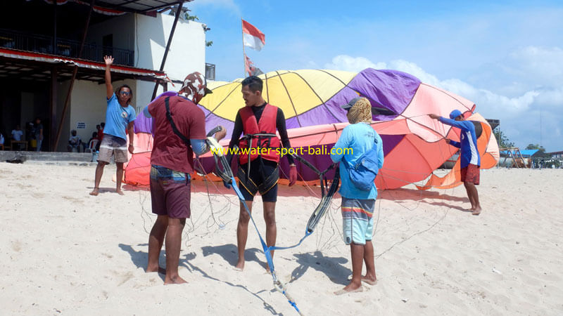 Tim persiapan parasailing memeriksa peralatan di Pantai Tanjung Benoa, Bali
