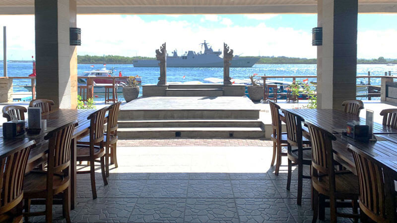 Pemandangan Surya Cafe Grill Seafood di Tanjung Benoa, dengan kapal di kejauhan