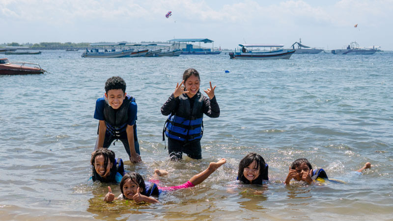 Anak-anak Bersenang-senang di Pantai Bali dengan Pakaian Water Sport