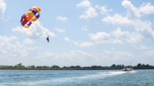 Peserta-peserta parasailing menikmati pemandangan laut biru di atas Tanjung Benoa, Bali.