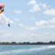 Peserta-peserta parasailing menikmati pemandangan laut biru di atas Tanjung Benoa, Bali.