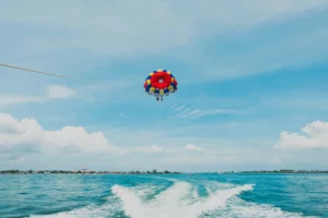 Parasailing di Bali dengan pemandangan laut yang indah, menunjukkan aktivitas seru yang dapat dinikmati oleh wisatawan.