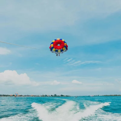 Parasailing di Bali dengan pemandangan laut yang indah, menunjukkan aktivitas seru yang dapat dinikmati oleh wisatawan.