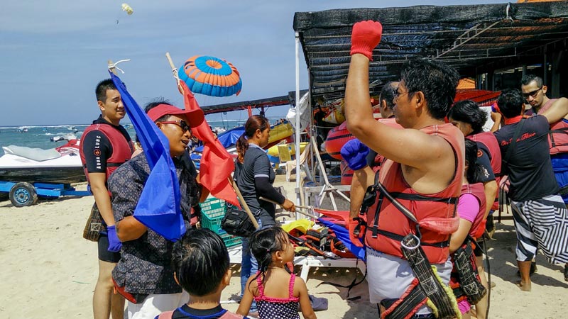 Staf memberi briefing sebelum water sport Bali, peserta pakai life jacket di pantai