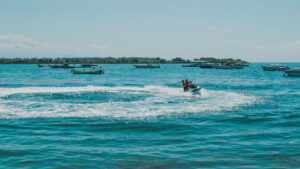 Pengunjung menikmati keseruan naik Jet Ski di Tanjung Benoa Bali dengan pemandangan laut biru.