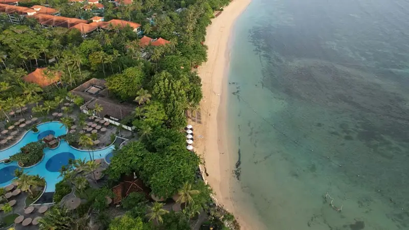 Pantai Nusa Dua dari udara, garis pantai rapi dan air jernih