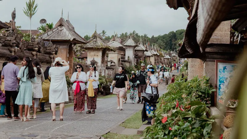 Wisatawan berjalan di Desa Penglipuran Bali, desa adat tradisional yang menjadi tempat wisata Bali populer.
