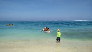 Aktivitas kano di Pantai Pandawa Bali dengan pemandangan air laut biru jernih dan langit cerah.