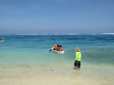 Aktivitas kano di Pantai Pandawa Bali dengan pemandangan air laut biru jernih dan langit cerah.