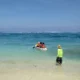 Aktivitas kano di Pantai Pandawa Bali dengan pemandangan air laut biru jernih dan langit cerah.