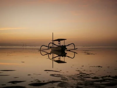 Sunrise di Pantai Sanur Bali dengan perahu jukung tradisional.