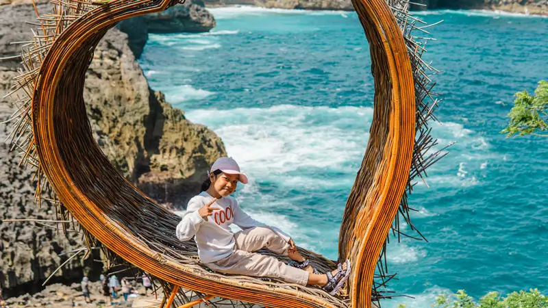Anak berpose di spot Instagramable tebing Nusa Penida dekat Broken Beach © Wira Tour Bali