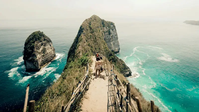 Wisatawan menuruni jalur curam ke Pantai Kelingking Nusa Penida.