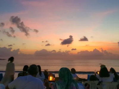 Suasana sunset romantis di Pantai Jimbaran Bali saat makan malam seafood © Wira Tour