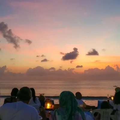 Suasana sunset romantis di Pantai Jimbaran Bali saat makan malam seafood © Wira Tour