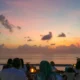Suasana sunset romantis di Pantai Jimbaran Bali saat makan malam seafood © Wira Tour