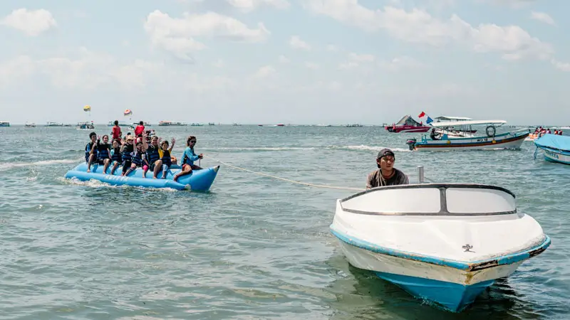 Keluarga naik banana boat di Tanjung Benoa – dokumentasi Wira Tour Bali