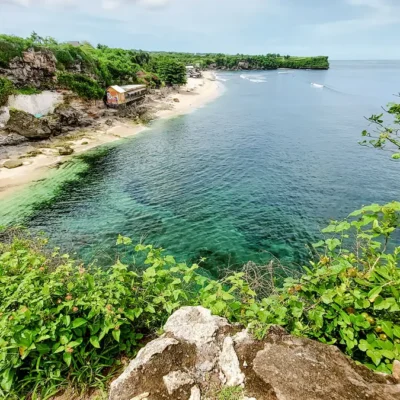 View tebing dan garis pantai berair jernih di Pantai Balangan Bali.