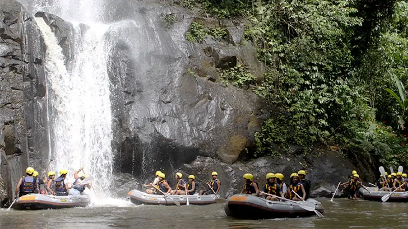 Perahu rafting berhenti di bawah air terjun kecil di jalur Ubud