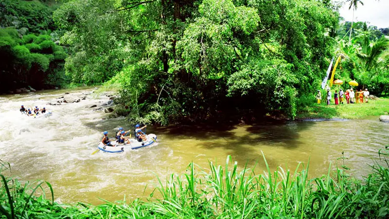 Perahu rafting menyusuri sungai dengan latar pepohonan tropis dan hutan Bali
