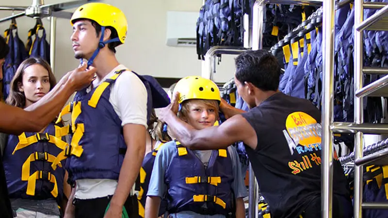 Staf memasangkan helm rafting ke anak sebelum trip di Ayung Ubud