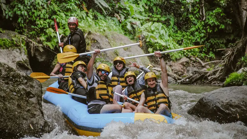 Ekspresi bahagia peserta rafting saat menyusuri Sungai Ayung di tengah hutan tropis