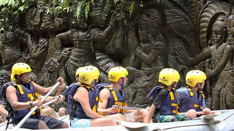 Peserta rafting melintasi ukiran batu khas Bali di tebing Sungai Ayung