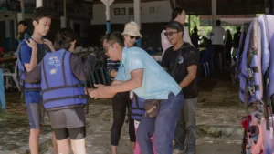 Tim Wira Tour Bali membantu wisatawan memakai pelampung sebelum aktivitas water sport di Tanjung Benoa