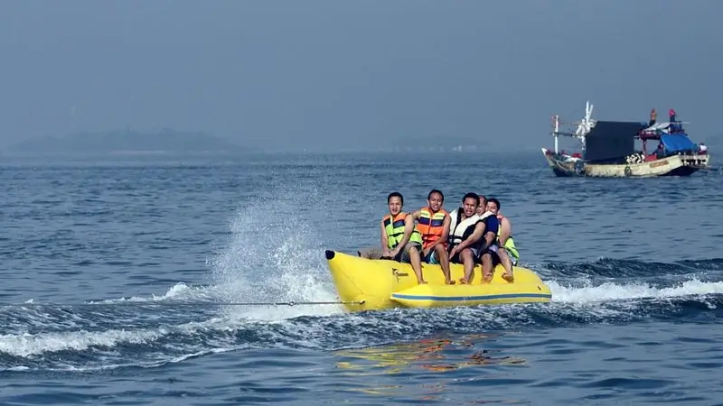 Rombongan naik banana boat di perairan tenang Sanur memakai pelampung