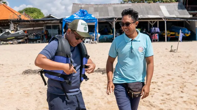 Staf Wira mendampingi peserta memasang life jacket sebelum briefing di Tanjung Benoa