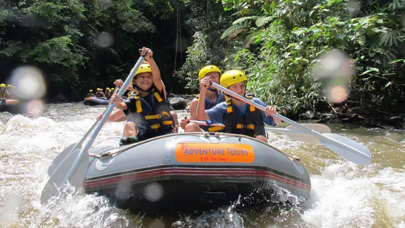Keluarga dengan anak menikmati arung jeram di sungai ramah anak di Ubud