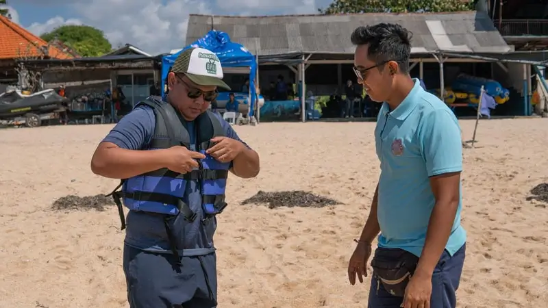 Briefing keselamatan watersport Tanjung Benoa: staf bantu pasang life jacket sebelum main