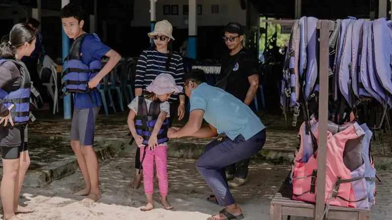 Petugas memasangkan pelampung untuk permainan pantai anak sebelum mulai