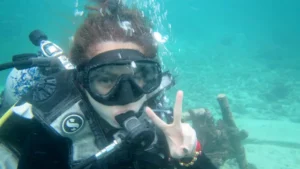 Harga scuba diving Tanjung Benoa: peserta intro scuba memberi tanda peace