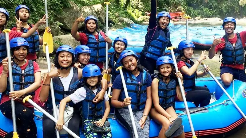 Anak dan remaja berhelm memakai jaket pelampung sebelum rafting