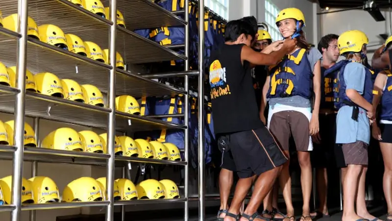 Staf membantu peserta memakai helm sebelum kayak Sungai Ayung Ubud