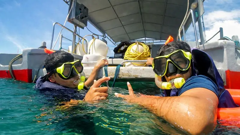 Peserta snorkeling dekat boat setelah masuk ke area aktivitas